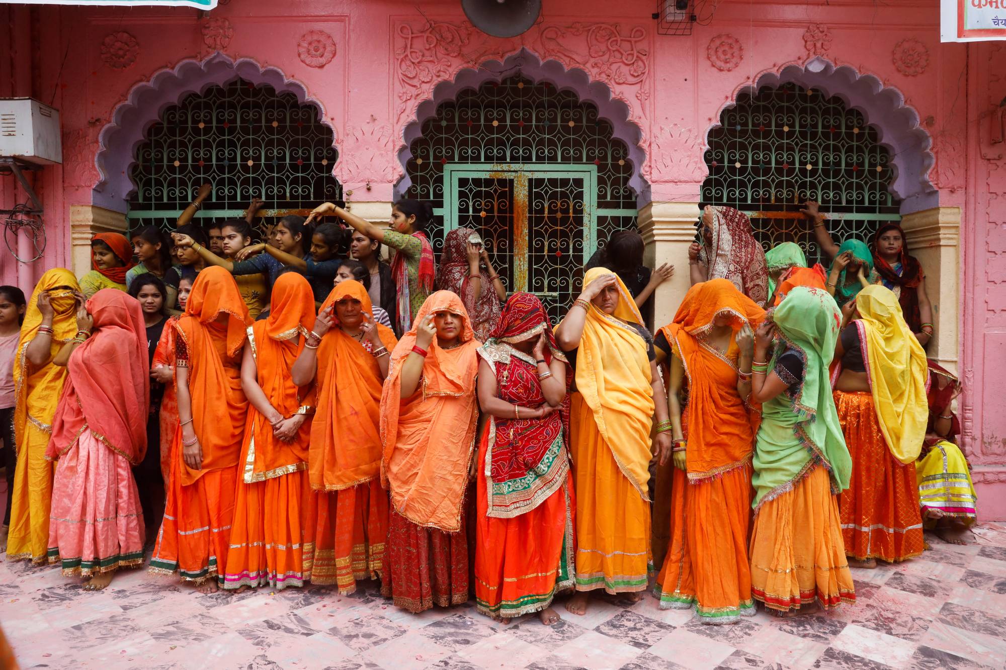 Women wait to take part in Huranga, a game played between men and women, a day after Holi at Dauji temple near the northern city of Mathura, India, on March 9. | REUTERS