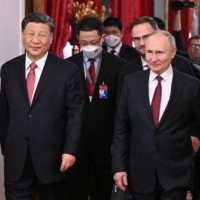 Russian President Vladimir Putin (right) and Chinese President Xi Jinping walk during a meeting at the Kremlin in Moscow on Tuesday.  | KREMLIN / VIA REUTERS