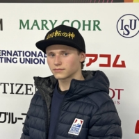 Malinin sports a cap with his \"QuadGod\" nickname written in Japanese during a media session in Saitama on Tuesday. | DAN ORLOWITZ
