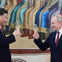 Chinese leader Xi Jinping and Russian President Vladimir Putin toast during a reception following their talks at the Kremlin in Moscow on Tuesday. | SPUTNIK / VIA AFP-JIJI