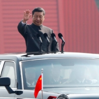 Chinese leader Xi Jinping waves from a vehicle as he reviews troops at a military parade marking the 70th founding anniversary of People\'s Republic of China, in Beijing in 2019. | REUTERS