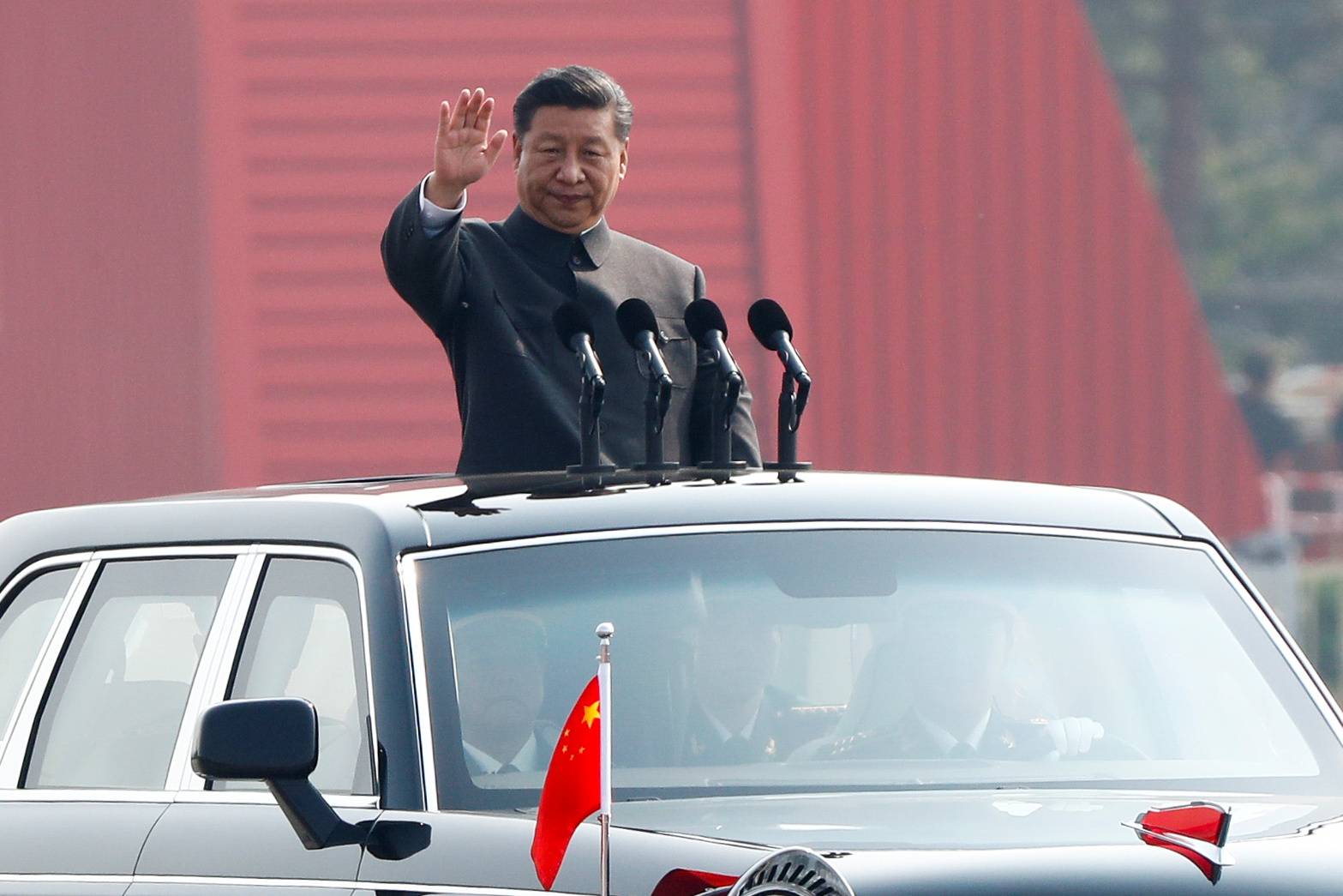 Chinese leader Xi Jinping waves from a vehicle as he reviews troops at a military parade marking the 70th founding anniversary of People's Republic of China, in Beijing in 2019. | REUTERS
