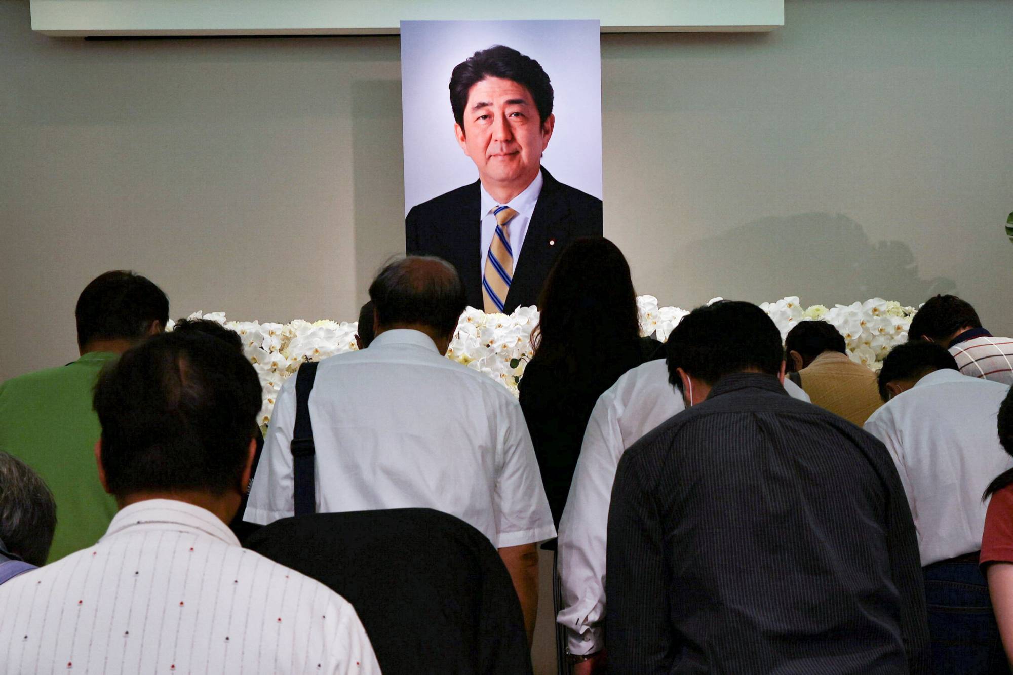 Taiwanese mourners pay their respects to late former Prime Minister Shinzo Abe, who was killed while campaigning for a parliamentary election, in Taipei last July. | REUTERS