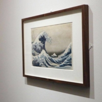 A woman looks at ukiyo-e artist Katsushika Hokusai\'s \"Under the Wave off Kanagawa\" displayed at an exhibit titled \"Hokusai: Beyond the Great Wave\" at the British Museum in London in May 2017. | KYODO