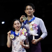 Gold medalists Riku Miura and Ryuichi Kihara celebrate on the podium after the pairs competition in Saitama on Thursday. | REUTERS