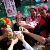 People wearing wigs symbolising cherry blossom toast together as they have a picnic underneath cherry trees at Ueno park in Tokyo, Japan April 5, 2017. REUTERS/Kim Kyung-Hoon | JASON JENKINS