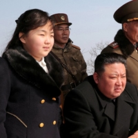 North Korean leader Kim Jong Un and his daughter, Ju Ae, watch a missile drill at an undisclosed location in this image released on Monday. | KCNA / VIA REUTERS  