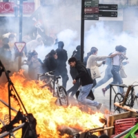 Protesters run in tear gas next to a street fire on the sidelines of a demonstration in Toulouse, southern France, on Thursday.  | AFP-JIJI