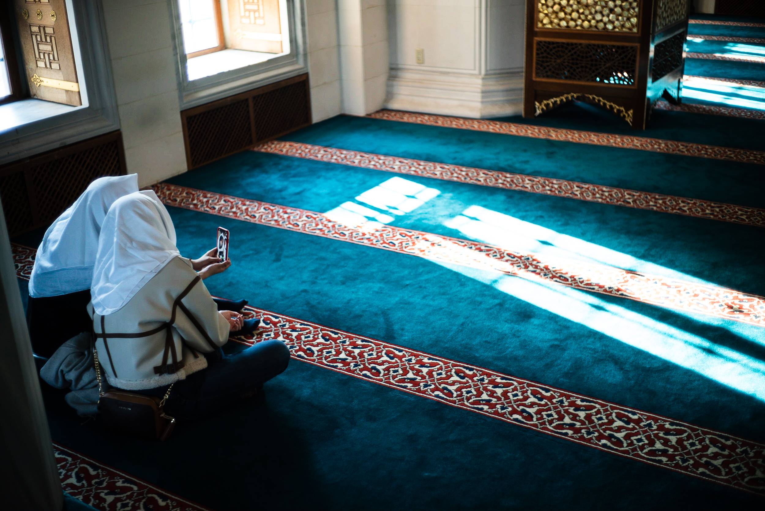 Two women check their smartphone while relaxing at Tokyo Camii. Experts suggest reaching out to people when you start to feel homesickness around religious occasions such as Ramadan.  | JOHAN BROOKS