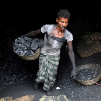 A worker carries coal in a basket in a industrial area in Mumbai. | REUTERS 