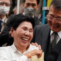 Hideko Hakamata (center) and Hideyo Ogawa, Iwao Hakamata\'s lawyer, smile after the Tokyo High Court ordered a retrial for a 1966 murder case on March 13. | AFP-JIJI