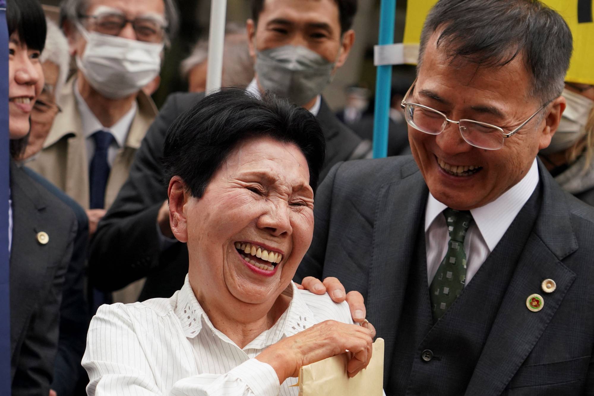 Hideko Hakamata (center) and Hideyo Ogawa, Iwao Hakamata's lawyer, smile after the Tokyo High Court ordered a retrial for a 1966 murder case on March 13. | AFP-JIJI