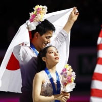 Ryuichi Kihara (left) and Riku Miura celebrate on the podium after winning pairs gold at the 2023 ISU World Figure Skating Championships in Saitama on Thursday. | REUTERS