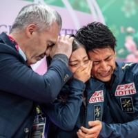 Riku Miura (center) and Ryuichi Kihara (right) react with coach Bruno Marcotte after their free skate score is announced at Saitama Super Arena on Thursday. | AFP-JIJI