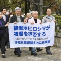 Plaintiffs and their lawyers of a lawsuit calling for suspension of the No. 3 reactor of the Ikata nuclear power plant head to the Hiroshima High Court on Friday. | KYODO
