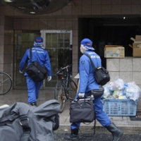 Police investigate the scene Saturday where twin 2-year-old brothers died after apparently falling from an apartment in the central city of Nagoya. | KYODO