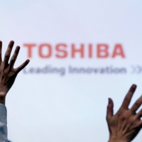 Reporters raise their hands for a question during a Toshiba news conference at the company headquarters in Tokyo. The rocky road to Toshiba\'s $15 billion sale to a group led by private equity firm Japan Industrial Partners is raising fresh doubts about the company\'s ability to navigate a fast-changing tech landscape. | REUTERS