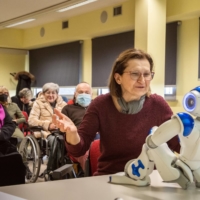 Daniela Cottafavi, 65, asks whether the robot would be able to get the doctor on the phone during a focus group in Carpi, Italy, on March 6. The Western world’s oldest population is facing a crisis of caregivers. Some are looking for a little helping, plastic, hand. | ALESSANDRO GRASSANI / THE NEW YORK TIMES