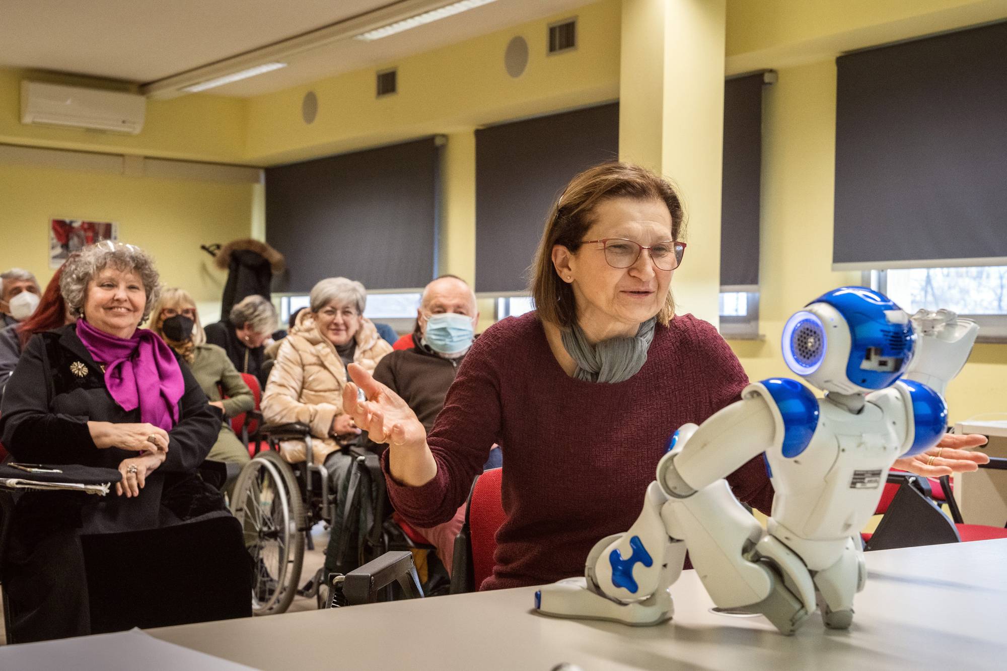 Daniela Cottafavi, 65, asks whether the robot would be able to get the doctor on the phone during a focus group in Carpi, Italy, on March 6. The Western world’s oldest population is facing a crisis of caregivers. Some are looking for a little helping, plastic, hand. | Alessandro Grassani / The New York Times