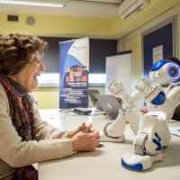 Bona Poli, 85, asks the robot Nao to tell her a story during a focus group in Carpi, Italy, on March 6. The Western world’s oldest population is facing a crisis of caregivers. Some are looking for a little helping, plastic, hand.  | ALESSANDRO GRASSANI / THE NEW YORK TIMES