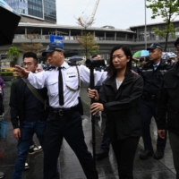Hong Kong Police watch as a group of residents hold the first authorized protest in several years, in the city\'s Tseung Kwan O district on Sunday. 

  | AFP-JIJI