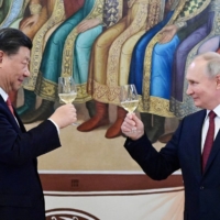 Russian President Vladimir Putin and Chinese leader Xi Jinping attend a reception at the Kremlin in Moscow on Tuesday. | SPUTNIK/ KREMLIN / VIA REUTERS 