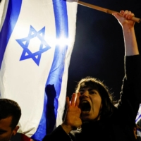 A protester at a demonstration against Israeli Prime Minister Benjamin Netanyahu\'s dismissal of his defense minister, in Jerusalem, on Monday | REUTERS