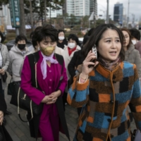 Lee Na-kyung (right) and other North Korean defectors walk to the Presidential Office for a meeting with the president\'s staff | BLOOMBERG