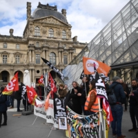 Employees block the entrance of Paris\' Musee du Louvre to denounce the government\'s controversial pension reform during a demonstration on Monday. | AFP-JIJI