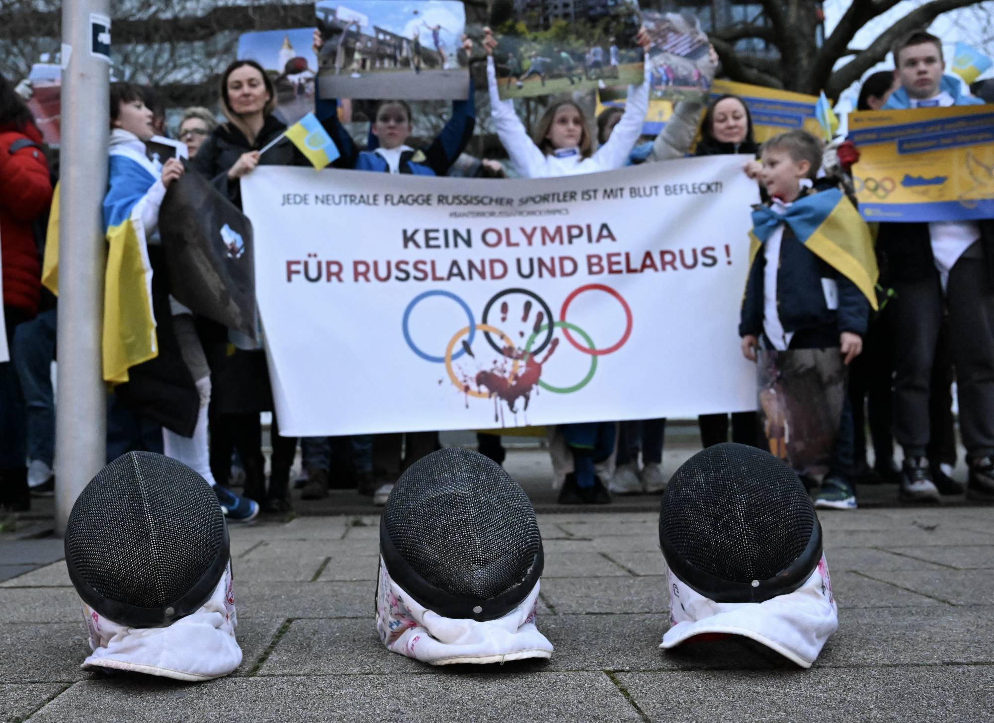 Ukrainian refugees protest against the participation of Russian and Belarusian athletes at the 2024 Paris Olympics before the visit of IOC President Thomas Bach to the Ruhr Political Forum in Essen, Germany, on March 22. | REUTERS