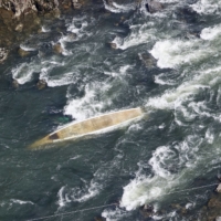 A capsized boat in the Hozu River in Kameoka, Kyoto Prefecture, on Tuesday | KYODO
