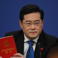Chinese Foreign Minister Qin Gang holds a copy of China\'s constitution during a news conference at the National People\'s Congress in Beijing on March 7. | AFP-JIJI