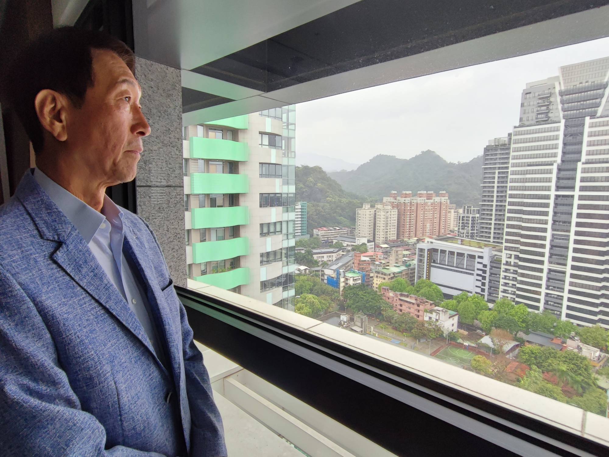 Man sitting beside glass window near high rise building photo