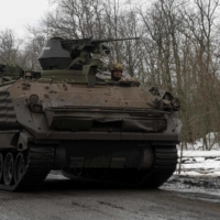 A Ukrainian serviceman drives an armored vehicle along a road near the front lines near Bakhmut on Saturday.  | AFP-JIJI