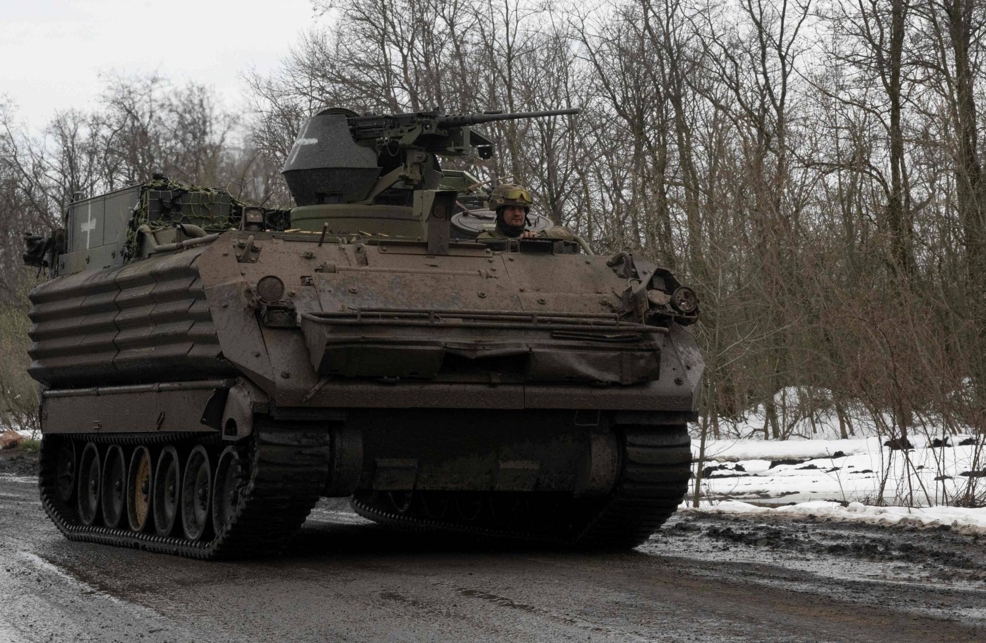 A Ukrainian serviceman drives an armored vehicle along a road near the front lines near Bakhmut on Saturday. | AFP-JIJI