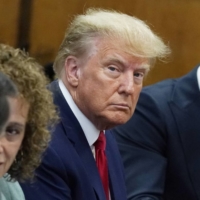 Former U.S. President Donald Trump appears in court with his legal team for an arraignment in New York on Tuesday. | POOL / VIA REUTERS 