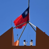 Taiwan\'s marine corps personnel lower Taiwan\'s national flag from the roof of Taiwan\'s Embassy in Tegucigalpa on March 26, as China and Honduras begin formal diplomatic relations. | AFP-JIJI