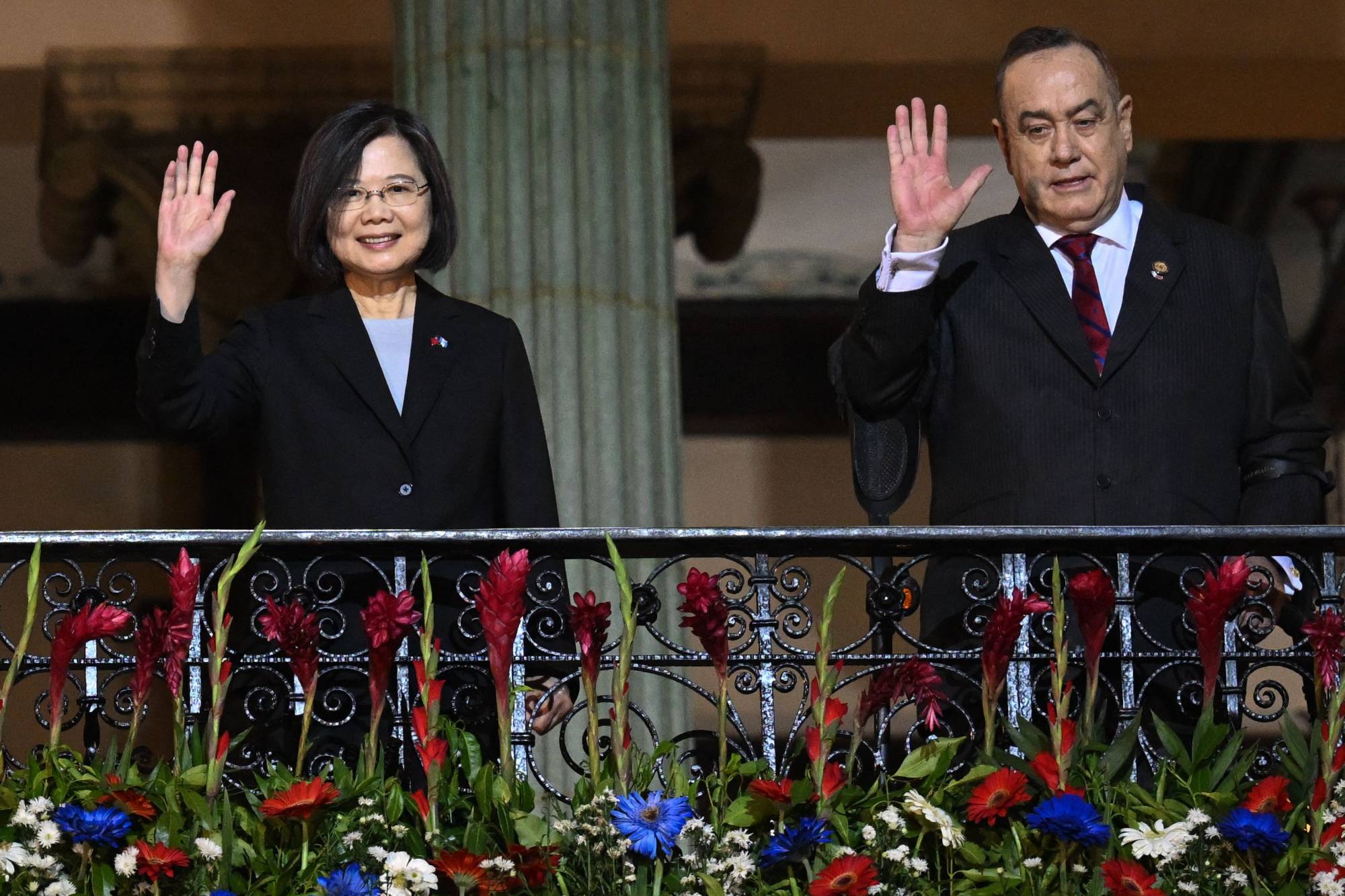 Taiwanese President Tsai Ing-wen (left) and Guatemala's President Alejandro Giammattei wave from a balcony at the Culture Palace in Guatemala City on March 31. | AFP-Jiji