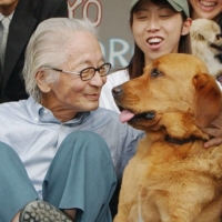 Masanori Hata, better known by his nickname \"Mutsugoro,\" poses with animals during a news conference in Tokyo in 2004. | KYODO