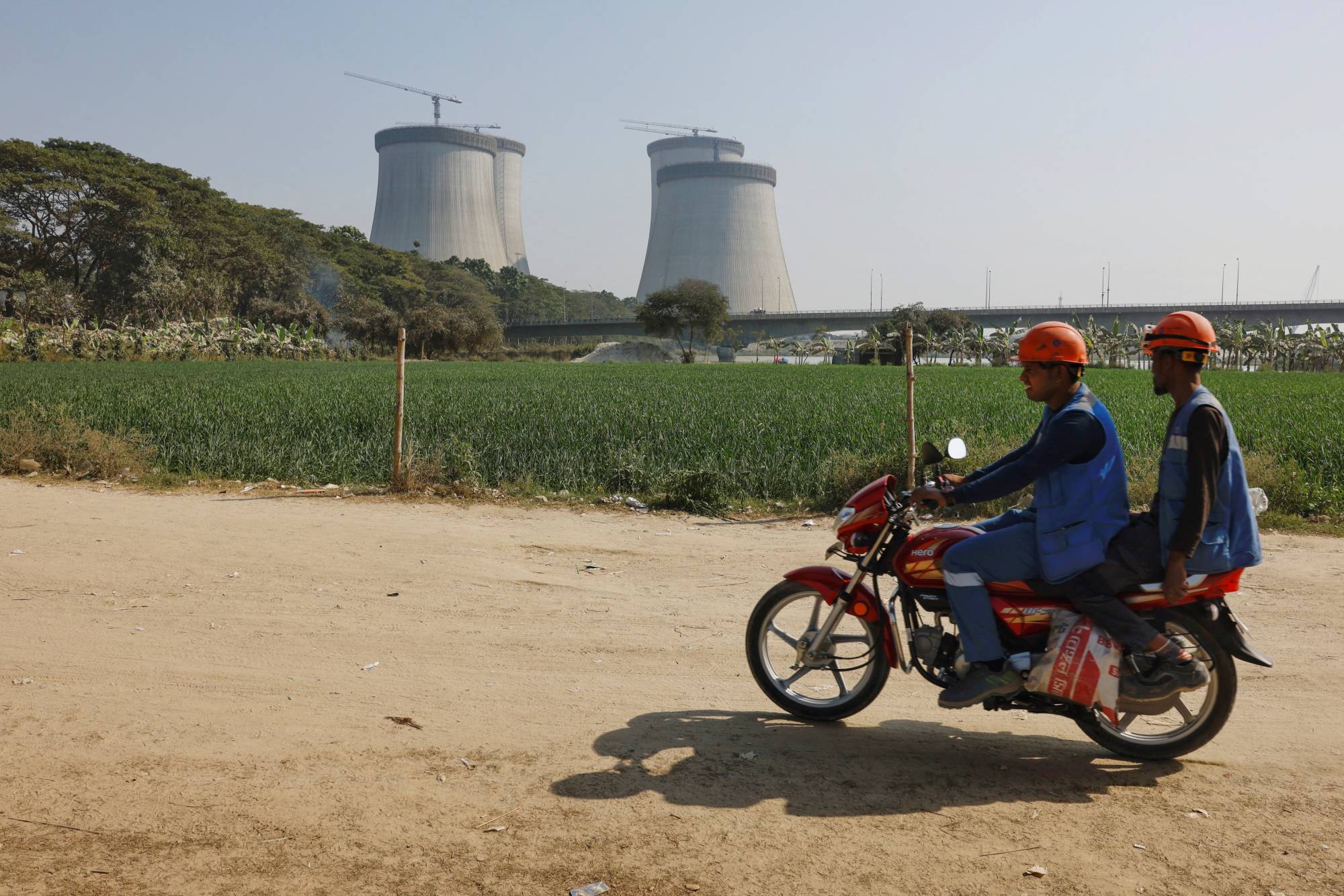 Two people pass by Rooppur Nuclear Power Plant, set to become Bangladesh's first nuclear power plant, west of Dhaka on February 14. | REUTERS
