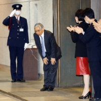 Outgoing Bank of Japan Gov. Haruhiko Kuroda prepares to leave the headquarters in Tokyo on Friday. | POOL / VIA REUTERS
