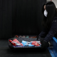 Lee Kyoung-ran, an official at Incheon Regional Customs, checks snacks that are suspected to contain drugs with an X-ray scanner at Incheon Regional Customs in Incheon, South Korea. | REUTERS