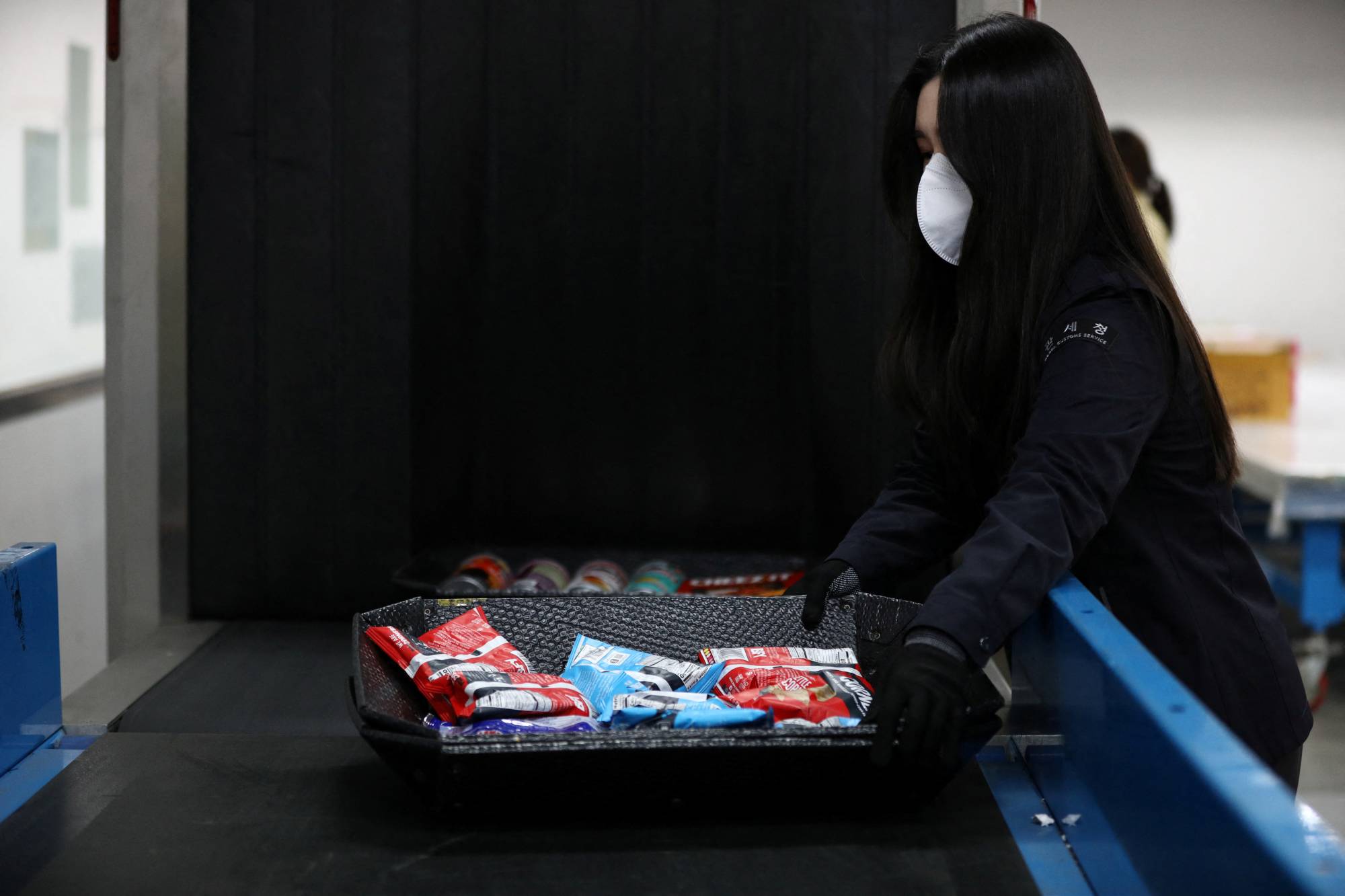 Lee Kyoung-ran, an official at Incheon Regional Customs, checks snacks that are suspected to contain drugs with an X-ray scanner at Incheon Regional Customs in Incheon, South Korea. | REUTERS