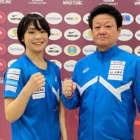Akari Fujinami poses with her father and coach Toshikazu after earning her 119th straight victory in Astana, Kazakhstan, on Wednesday. | KYODO