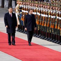 French President Emmanuel Macron reviews an honor guard with Chinese leader Xi Jinping at a welcoming ceremony in Beijing on April 6. | AFP-JIJI