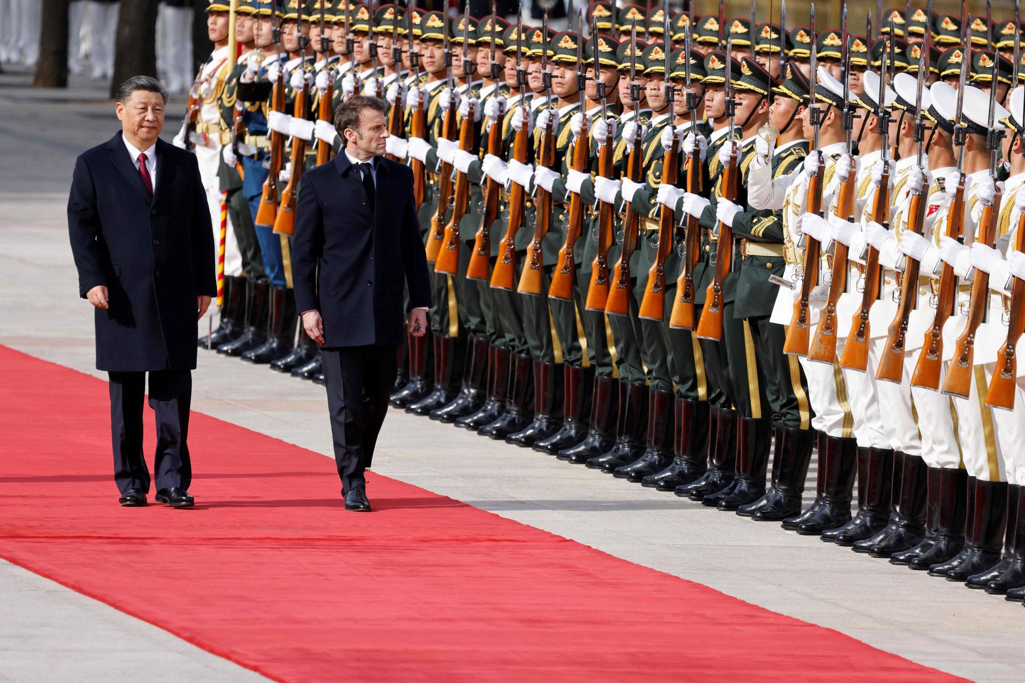 French President Emmanuel Macron reviews an honor guard with Chinese leader Xi Jinping at a welcoming ceremony in Beijing on April 6. | AFP-JIJI