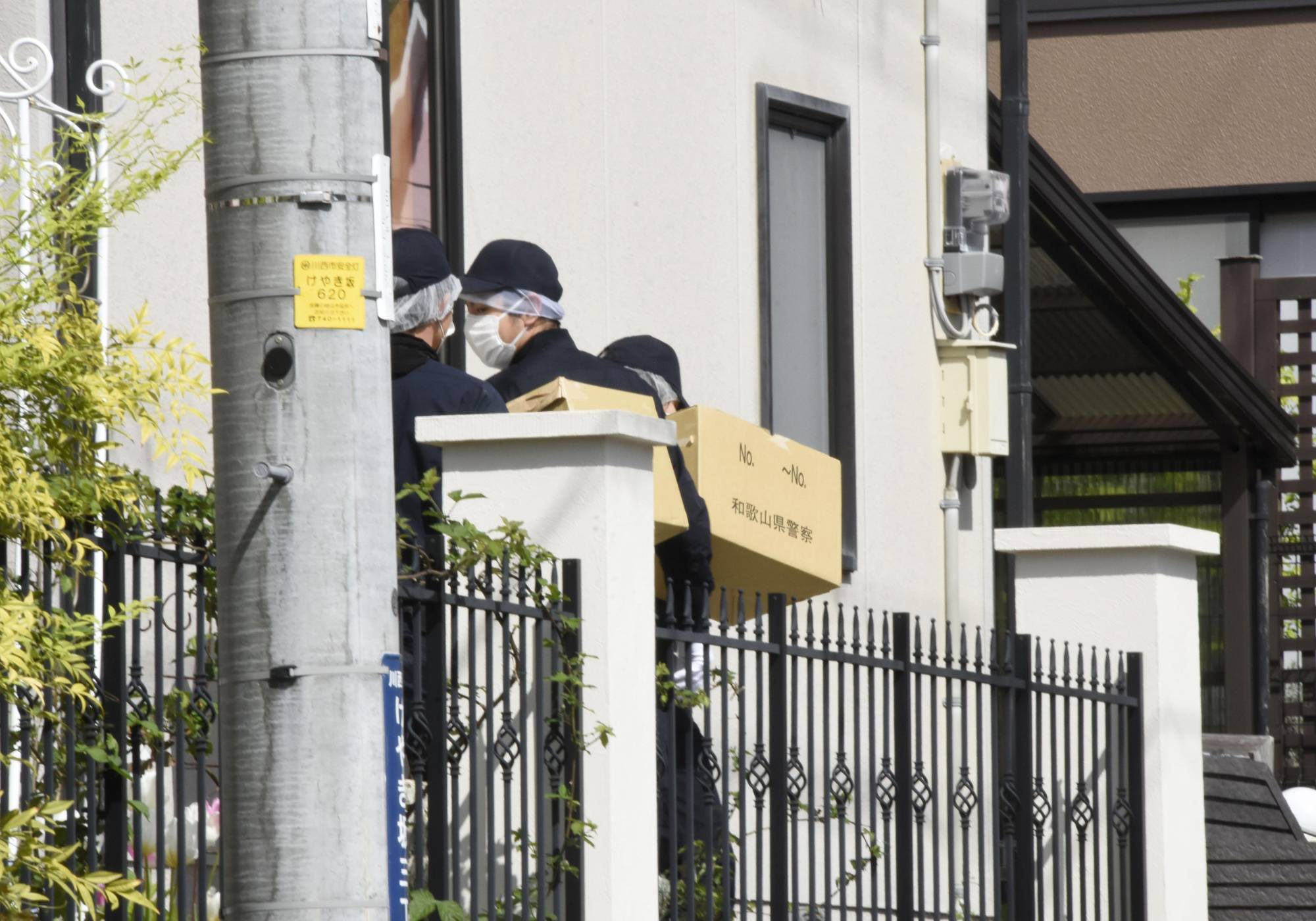 Investigators carry boxes of seized items after searching the hoem of Ryuji Kimura in Kawanishi, Hyogo Prefecture, on Sunday. Kimura was arrested the previous day in relation to an explosion in Wakayama that forced Prime Minister Fumio Kishida to be evacuated. | KYODO