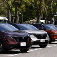 Nissan\'s Ariya electric crossover SUVs and an X-Trail SUV during a test driving event in Tokyo on Monday. The firm has unveiled a new electric SUV at the Shanghai auto show, highlighting its commitment to the Chinese market. | BLOOMBERG