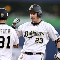 The Buffaloes\' Frank Schwindel is congratulated by coach So Taguchi after his tiebreaking hit against the Eagles during the eighth inning in Osaka on Thursday. | KYODO