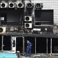 An investigator inspects the damage at the Changfeng Hospital in Beijing on Wednesday after a fire broke out the day before.  | AFP-JIJI